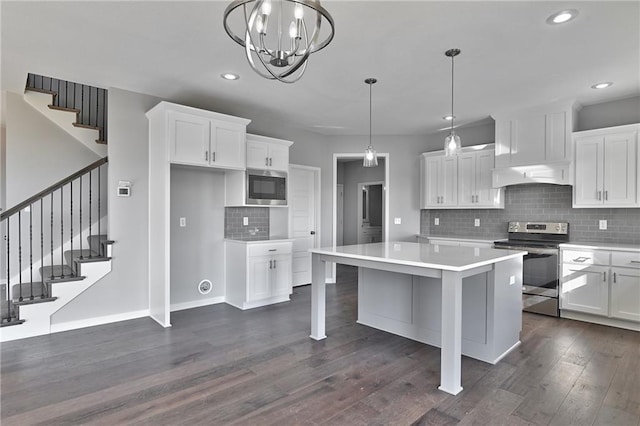 kitchen featuring custom exhaust hood, a center island, white cabinets, and appliances with stainless steel finishes