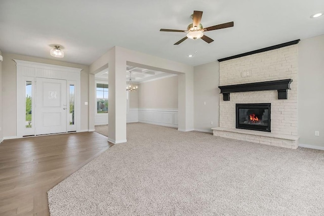 17165 W 164th Ter, Olathe, KS 66062 - carpeted foyer entrance featuring a ceiling fan, a stone fireplace, a chandelier, and a wainscoted wall