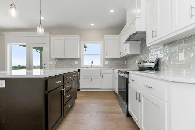 17165 W 164th Ter, Olathe, KS 66062 - kitchen with stainless steel electric stove, white cabinets, light countertops, backsplash, and light wood-type flooring