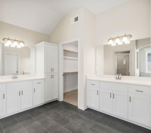 17165 W 164th Ter, Olathe, KS 66062 - full bathroom featuring two vanities, vaulted ceiling, tile patterned flooring, a stall shower, and a walk in closet