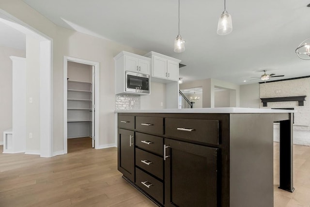 17165 W 164th Ter, Olathe, KS 66062 - kitchen with stainless steel microwave, a ceiling fan, white cabinetry, light wood-type flooring, and light countertops