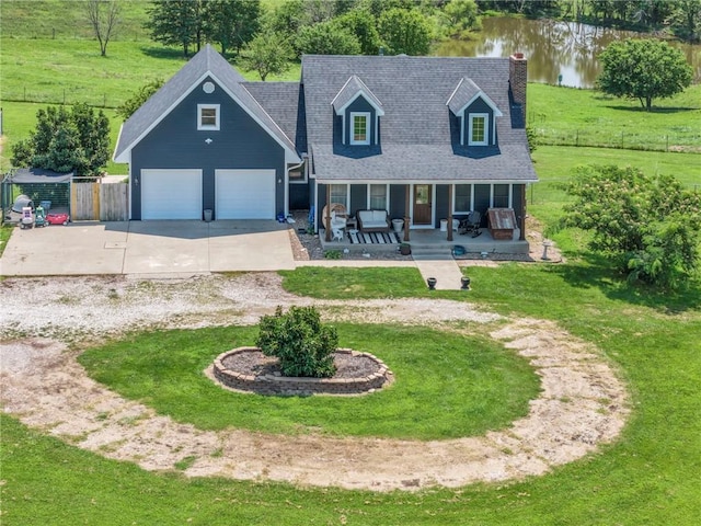 new england style home with a front lawn, a porch, a water view, and a garage