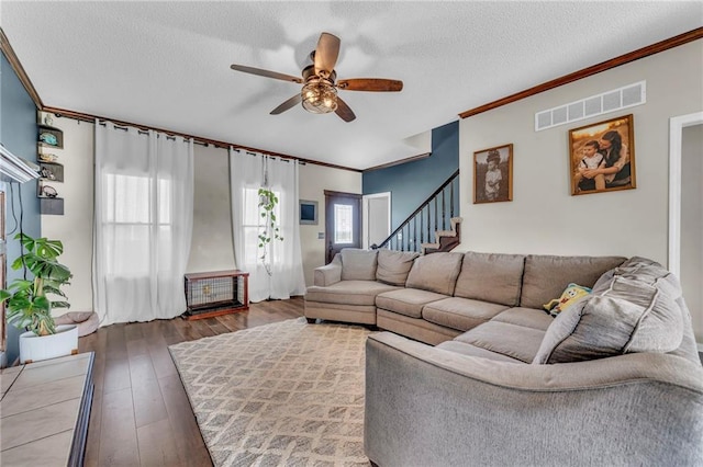 living room featuring ceiling fan, dark hardwood / wood-style flooring, a healthy amount of sunlight, and a textured ceiling