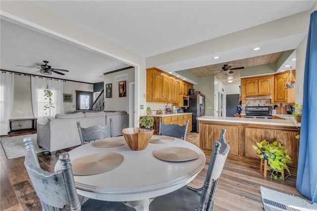 dining area with ceiling fan and light hardwood / wood-style floors