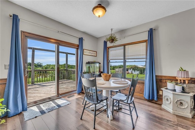 dining area featuring a textured ceiling and hardwood / wood-style flooring