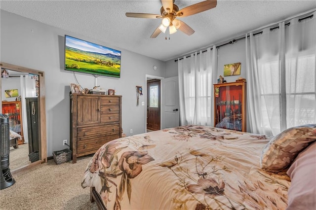 carpeted bedroom featuring ceiling fan and a textured ceiling