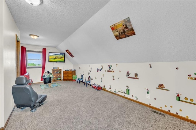 game room featuring carpet floors, a textured ceiling, and vaulted ceiling