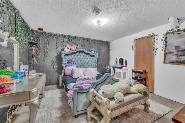 bedroom with a textured ceiling and hardwood / wood-style flooring