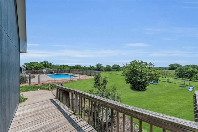 wooden deck featuring a fenced in pool and a lawn