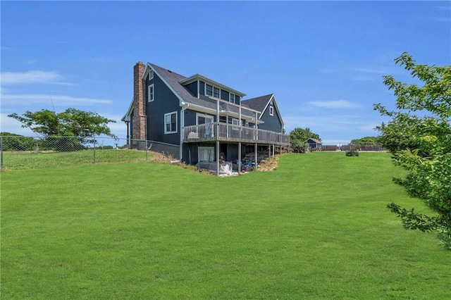 back of property featuring a yard and a wooden deck