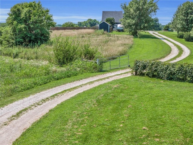 view of property's community with a rural view and a yard