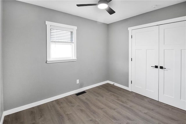 unfurnished bedroom with hardwood / wood-style floors, ceiling fan, and a closet