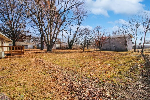 view of yard with a deck and central AC unit