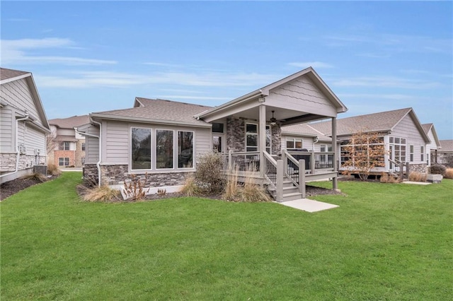 6975 W 162nd Ter, Overland Park, KS 66085 - rear view of property with ceiling fan, stone siding, a lawn, and a deck