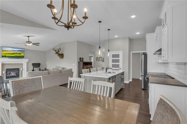 6975 W 162nd Ter, Overland Park, KS 66085 - dining area with dark wood-style floors, ceiling fan, a glass covered fireplace, lofted ceiling, and recessed lighting