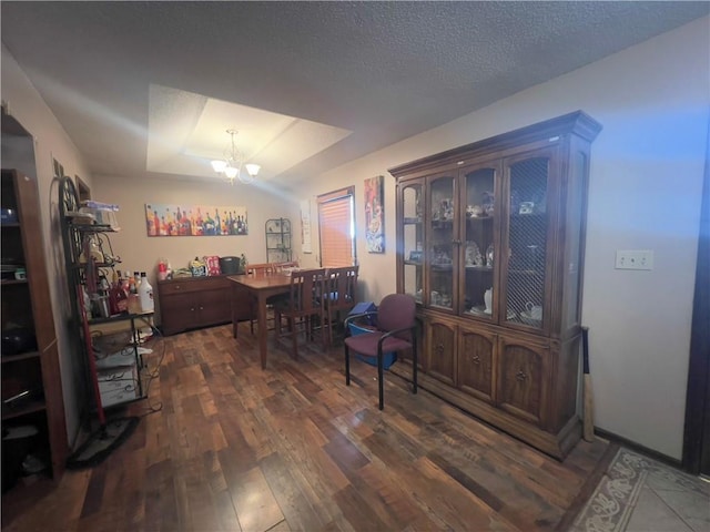 home office featuring lofted ceiling, a textured ceiling, a chandelier, and dark hardwood / wood-style floors