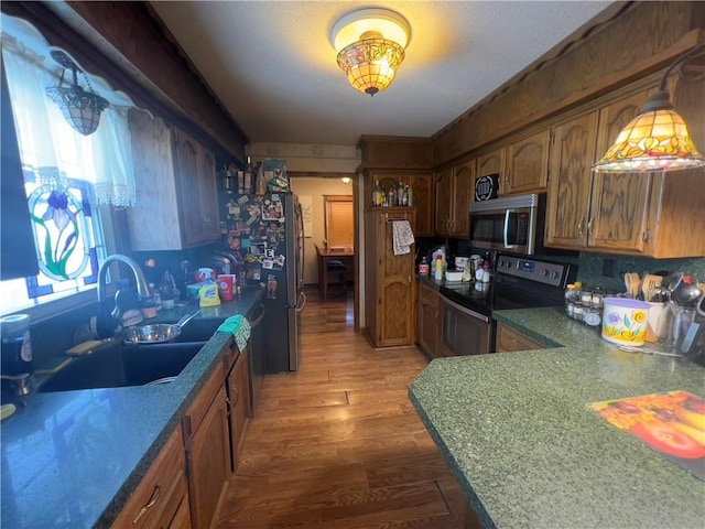 kitchen with sink, stainless steel appliances, decorative backsplash, and wood-type flooring