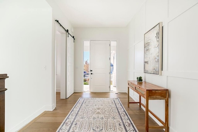 interior space with a barn door and light hardwood / wood-style flooring