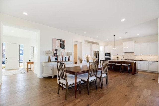 dining area featuring sink and wood-type flooring