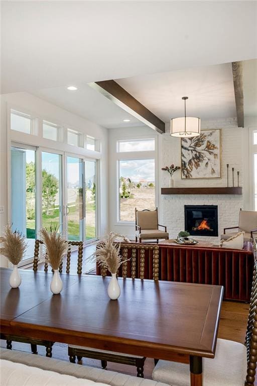 dining space with beamed ceiling, wood-type flooring, and a wealth of natural light