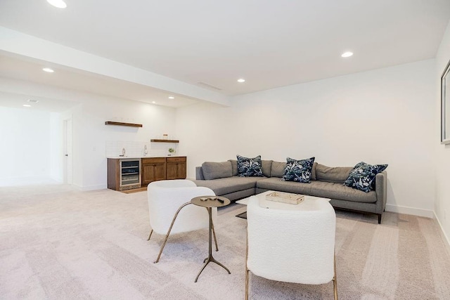 carpeted living room with bar area, beverage cooler, and beam ceiling