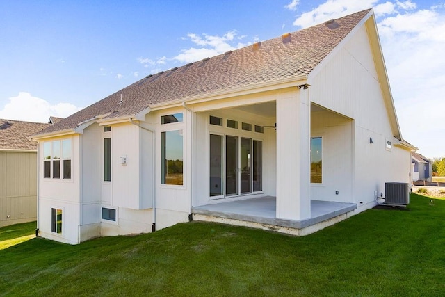 rear view of house with a yard, a patio, and central AC