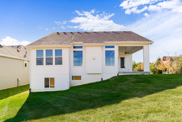 rear view of house with a yard and ceiling fan