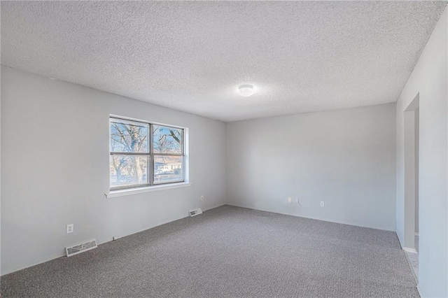 carpeted empty room with a textured ceiling