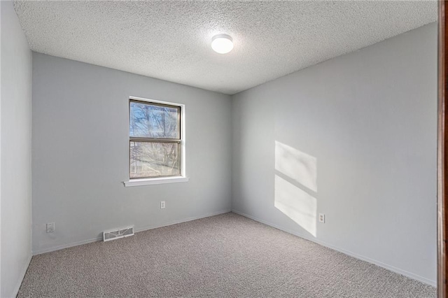 carpeted empty room with a textured ceiling