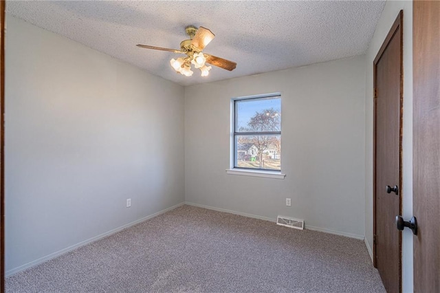 empty room with ceiling fan, carpet, and a textured ceiling