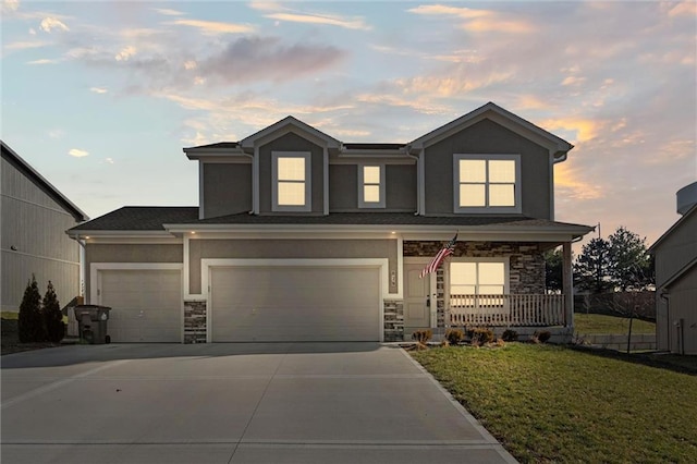 view of front of house featuring a lawn, a porch, and a garage