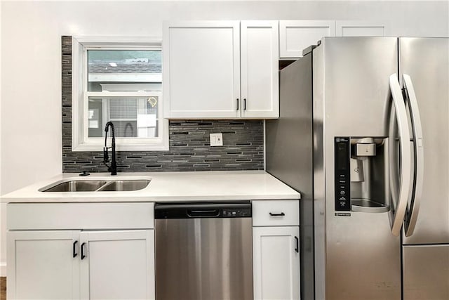 kitchen with sink, white cabinets, decorative backsplash, and appliances with stainless steel finishes