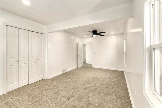 unfurnished bedroom with ceiling fan, a closet, and carpet