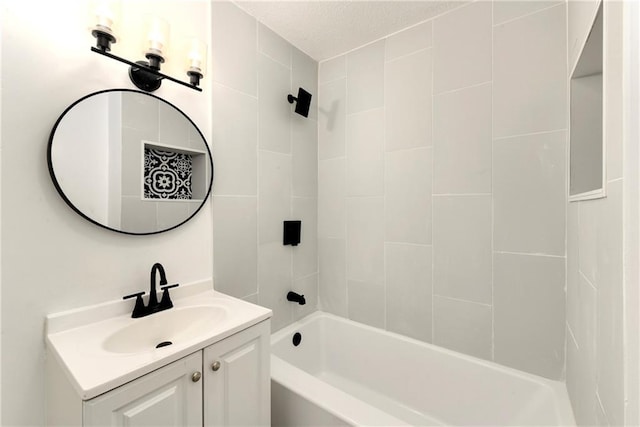 bathroom with tiled shower / bath and vanity