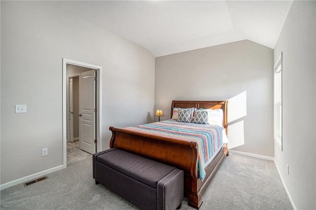 bedroom featuring light colored carpet and vaulted ceiling