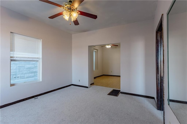 unfurnished room featuring light carpet and ceiling fan