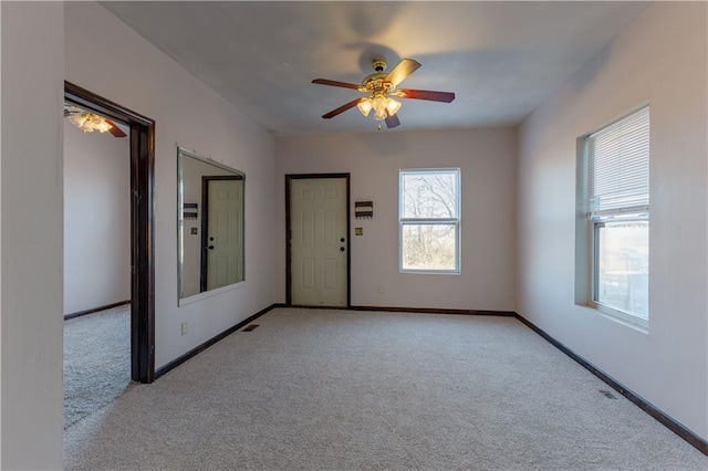 empty room with ceiling fan and light colored carpet