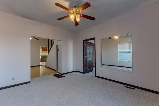 empty room featuring ceiling fan and light colored carpet