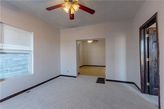 carpeted spare room with ceiling fan