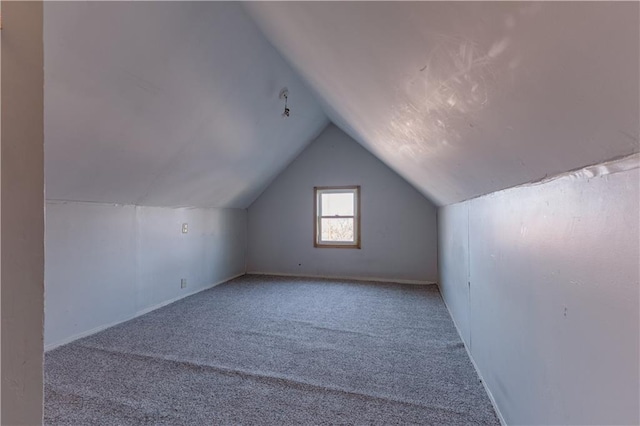 additional living space featuring vaulted ceiling and light carpet