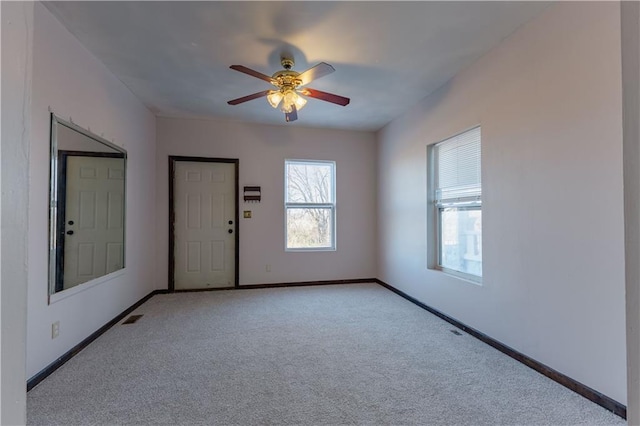 carpeted spare room featuring ceiling fan