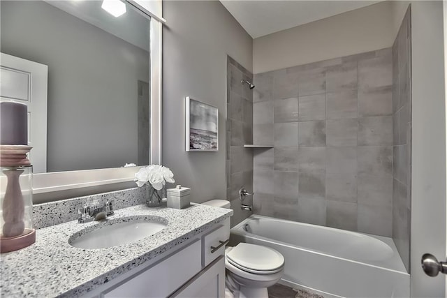 full bathroom with tiled shower / bath, vanity, and toilet