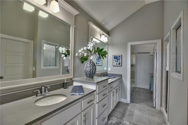 bathroom featuring vanity, lofted ceiling, and tile patterned floors