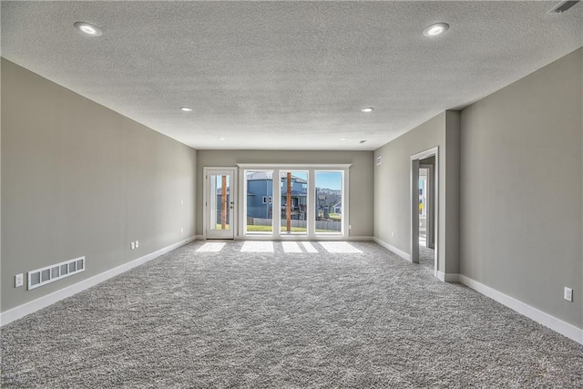 spare room with a textured ceiling and carpet flooring