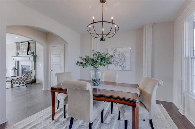 dining area with hardwood / wood-style floors and an inviting chandelier