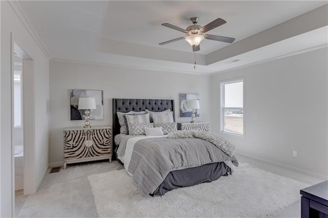 bedroom with light carpet, a tray ceiling, crown molding, and ceiling fan