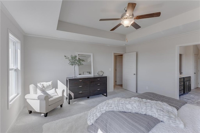 carpeted bedroom with ceiling fan and a tray ceiling