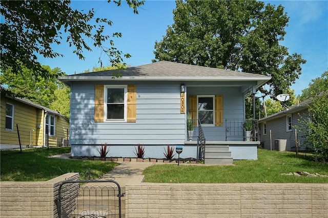 rear view of house with a lawn and a porch