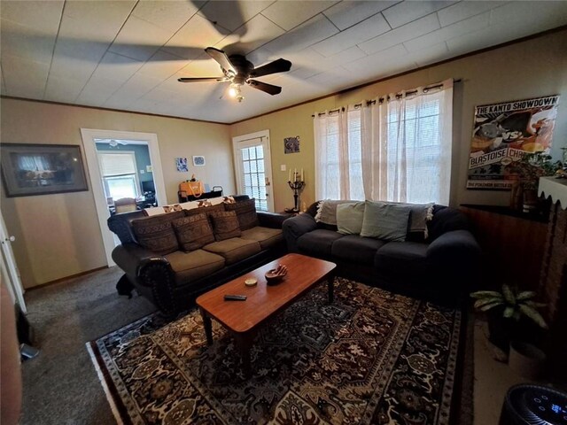 living room featuring carpet flooring, a wealth of natural light, ceiling fan, and crown molding