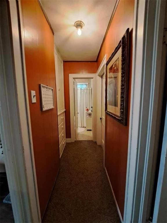 hall with dark carpet and wooden walls